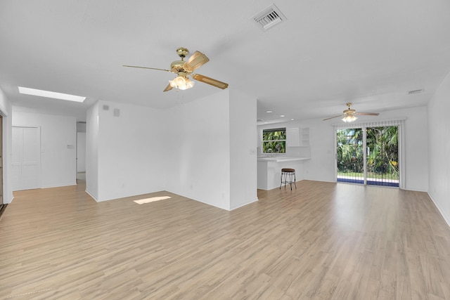 5801 SE Cable Dr, Stuart, FL 34997 - unfurnished living room with a ceiling fan, light wood-style flooring, and a skylight