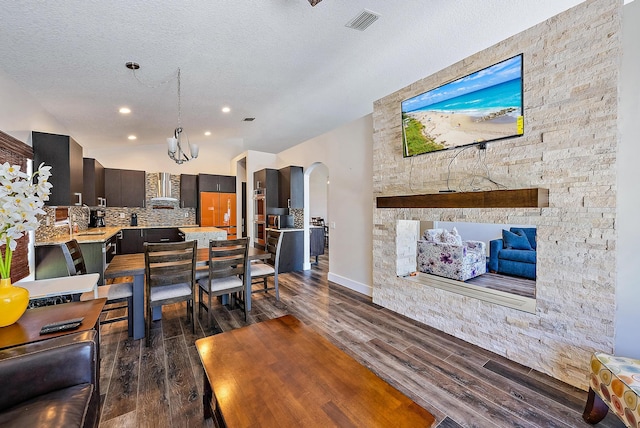 7727 Colony Lake Dr, Boynton Beach, FL 33436 - living room with dark wood-type flooring, arched walkways, a chandelier, a textured ceiling, and recessed lighting