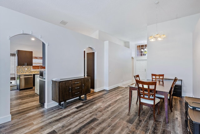7727 Colony Lake Dr, Boynton Beach, FL 33436 - dining space featuring arched walkways, dark wood-style flooring, and a chandelier