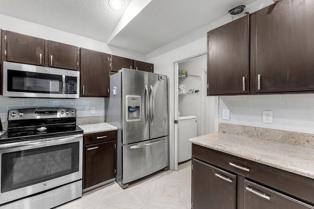 7782 Stirling Bridge Blvd S, Delray Beach, FL 33446 - kitchen with stainless steel appliances, tasteful backsplash, independent washer and dryer, dark brown cabinets, and light stone counters