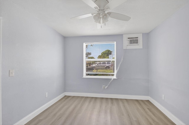 323 S E St, Lake Worth Beach, FL 33460 - spare room featuring a wall unit AC, light wood-style flooring, and a ceiling fan