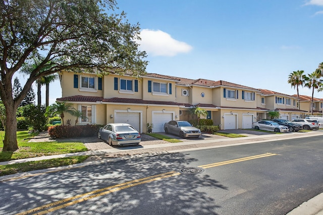 3004 N Evergreen Cir, Boynton Beach, FL 33426 - view of property featuring an attached garage, driveway, a residential view, stucco siding, and a tiled roof