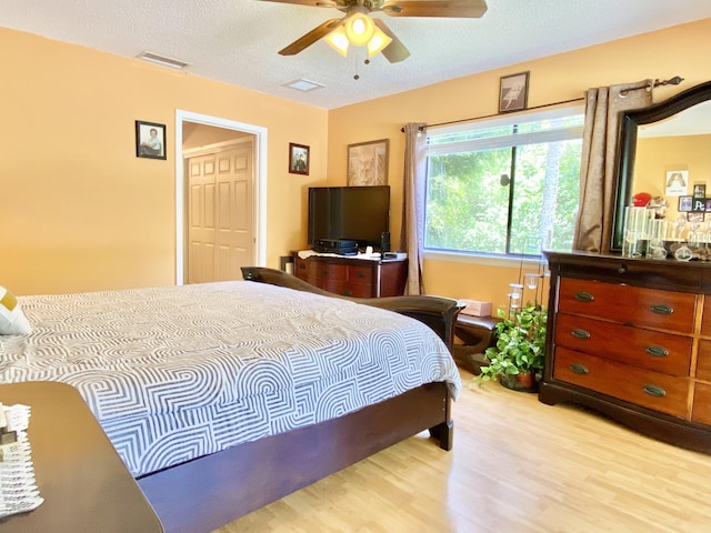 16651 96th Ter N, Jupiter, FL 33478 - bedroom with light wood-style floors, a textured ceiling, and a ceiling fan