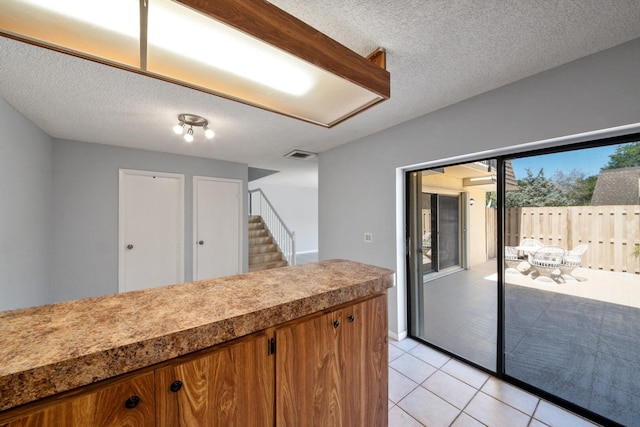 2897 SW 22nd Cir Unit 44B, Delray Beach, FL 33445 - kitchen featuring light tile patterned floors, a textured ceiling, and brown cabinets