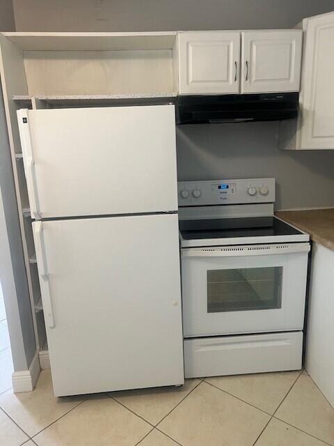 1829 N A St Unit 74, Lake Worth, FL 33460 - kitchen featuring white appliances, under cabinet range hood, light tile patterned floors, and white cabinetry