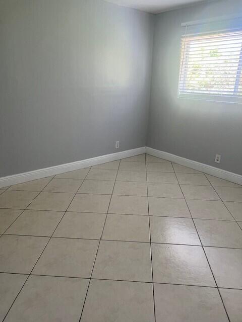 1829 N A St Unit 74, Lake Worth, FL 33460 - spare room with light tile patterned floors and baseboards