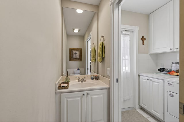3032 W Community Dr, Jupiter, FL 33458 - bathroom featuring washer / dryer, vanity, and backsplash