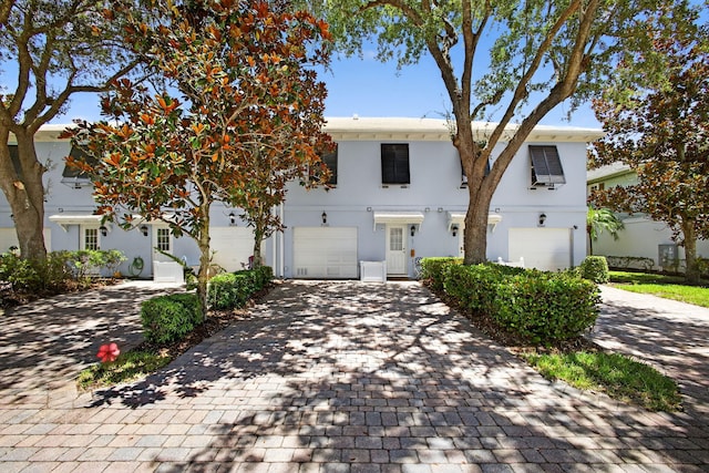 3032 W Community Dr, Jupiter, FL 33458 - view of front of property featuring an attached garage, decorative driveway, and stucco siding