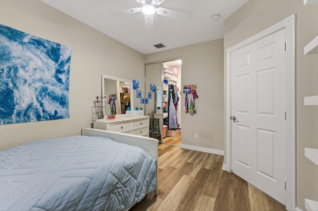 3032 W Community Dr, Jupiter, FL 33458 - bedroom featuring wood finished floors, a closet, a spacious closet, and a ceiling fan