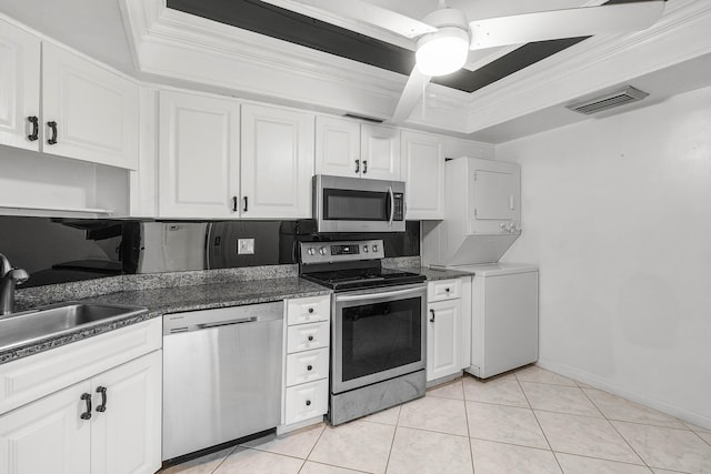 2400 Presidential Way Unit 903, West Palm Beach, FL 33401 - kitchen with appliances with stainless steel finishes, stacked washer / drying machine, a raised ceiling, crown molding, and white cabinetry