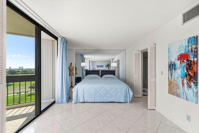 2400 Presidential Way Unit 903, West Palm Beach, FL 33401 - bedroom featuring light tile patterned flooring, a textured ceiling, and access to outside