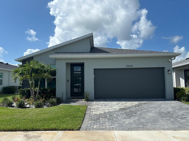 12664 SW Eleanor Dr, Port Saint Lucie, FL 34987 - ranch-style home with stucco siding, an attached garage, driveway, and a front lawn