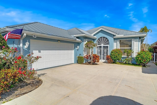 2619 SW Greenwich Way, Palm City, FL 34990 - ranch-style house featuring driveway, a garage, a metal roof, stucco siding, and a standing seam roof