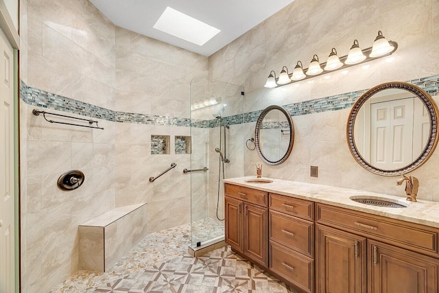 2619 SW Greenwich Way, Palm City, FL 34990 - full bathroom featuring a skylight, walk in shower, double vanity, and tile walls