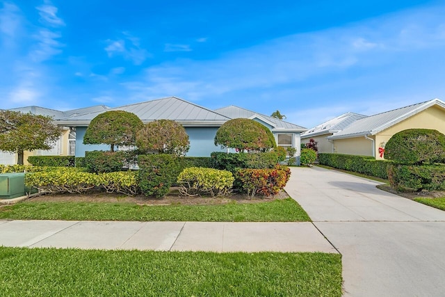 2619 SW Greenwich Way, Palm City, FL 34990 - view of front facade with a standing seam roof, driveway, a metal roof, and stucco siding