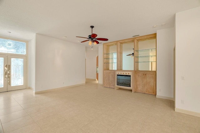 2619 SW Greenwich Way, Palm City, FL 34990 - unfurnished living room with a glass covered fireplace, ceiling fan, and french doors