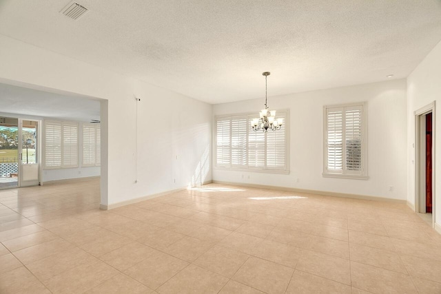 2619 SW Greenwich Way, Palm City, FL 34990 - unfurnished room featuring a textured ceiling, healthy amount of natural light, a chandelier, and light tile patterned flooring