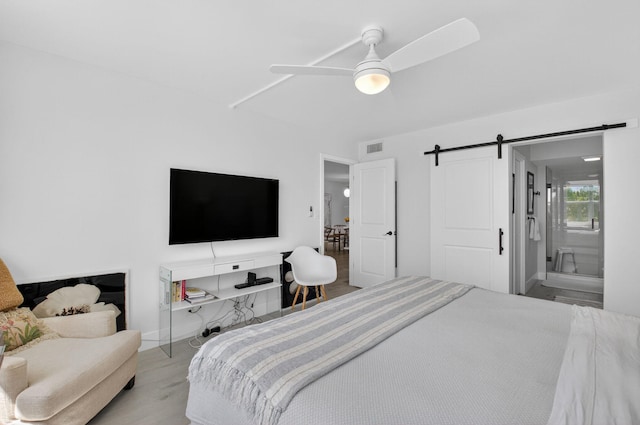 930 Dogwood Dr Unit 358, Delray Beach, FL 33483 - bedroom with a barn door, wood finished floors, and ceiling fan