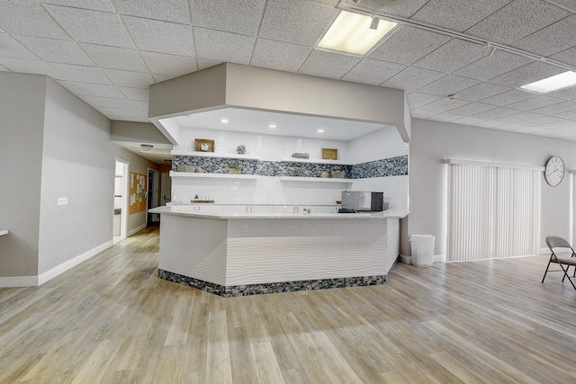 930 Dogwood Dr Unit 358, Delray Beach, FL 33483 - kitchen featuring open shelves, a drop ceiling, light wood-style flooring, and a peninsula