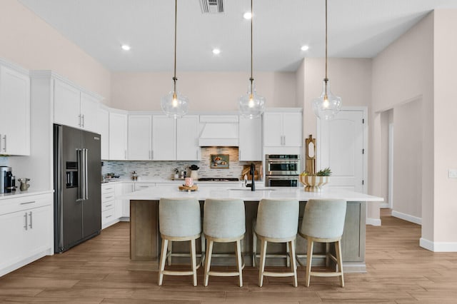 9109 Balsamo Dr, Palm Beach Gardens, FL 33412 - kitchen featuring appliances with stainless steel finishes, custom range hood, light countertops, tasteful backsplash, and recessed lighting