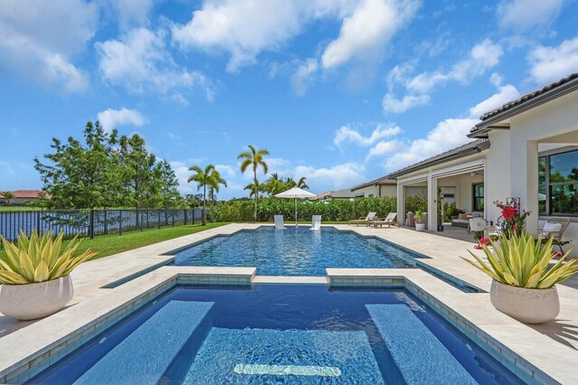 9109 Balsamo Dr, Palm Beach Gardens, FL 33412 - view of swimming pool featuring a patio, a fenced backyard, and a pool with connected hot tub