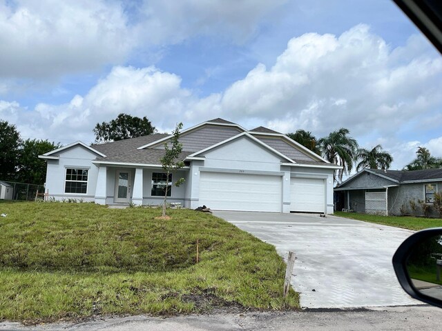 209 SW Christmas Ter, Port Saint Lucie, FL 34984 - ranch-style house featuring driveway, stucco siding, an attached garage, a shingled roof, and a front lawn