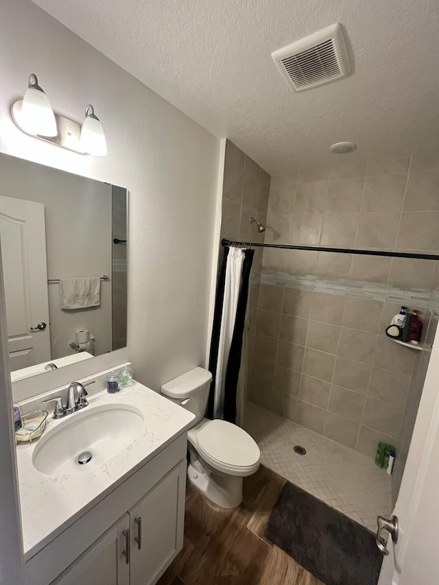 209 SW Christmas Ter, Port Saint Lucie, FL 34984 - full bathroom with a tile shower, wood finished floors, vanity, and a textured ceiling