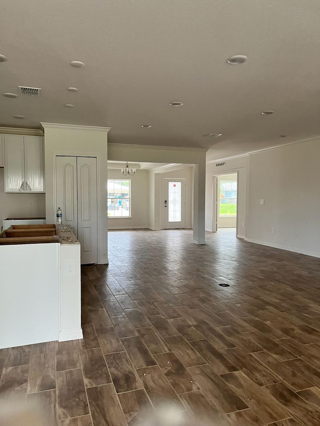 209 SW Christmas Ter, Port Saint Lucie, FL 34984 - unfurnished living room with crown molding, healthy amount of natural light, a chandelier, dark wood-type flooring, and recessed lighting