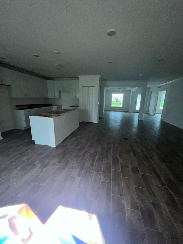 209 SW Christmas Ter, Port Saint Lucie, FL 34984 - kitchen featuring white cabinetry, a kitchen island, open floor plan, and dark wood-type flooring