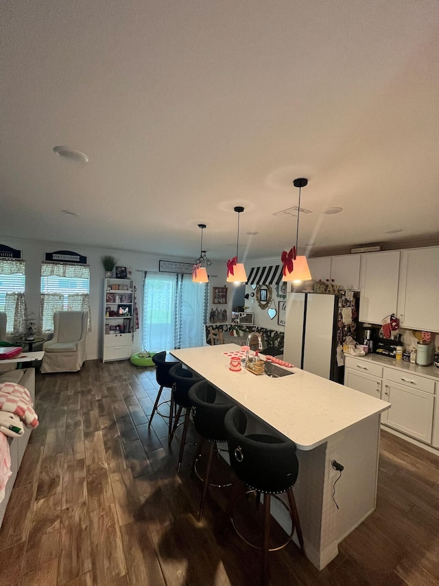 209 SW Christmas Ter, Port Saint Lucie, FL 34984 - kitchen with freestanding refrigerator, dark wood-type flooring, white cabinets, and light countertops