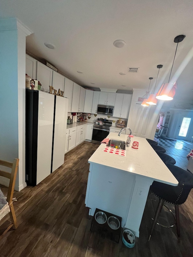 209 SW Christmas Ter, Port Saint Lucie, FL 34984 - kitchen with stainless steel appliances, dark wood-style floors, light countertops, and pendant lighting