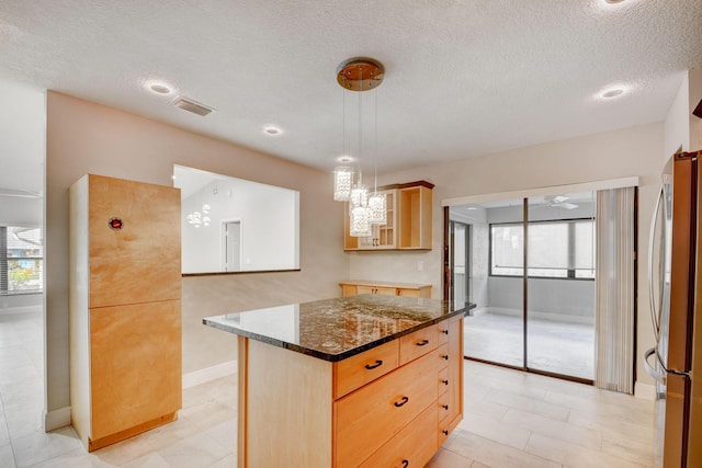 6170 Serene Run, Lake Worth, FL 33463 - kitchen with freestanding refrigerator, light brown cabinets, dark stone countertops, plenty of natural light, and a textured ceiling