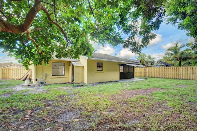 6170 Serene Run, Lake Worth, FL 33463 - rear view of house with stucco siding, a fenced backyard, and a sunroom