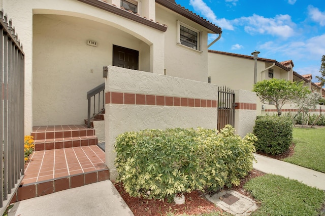 1102 Republic Ct, Deerfield Beach, FL 33442 - property entrance featuring stucco siding and a gate
