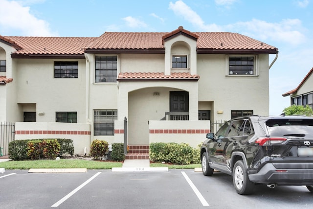 1102 Republic Ct, Deerfield Beach, FL 33442 - view of front facade featuring uncovered parking, stucco siding, and a tile roof