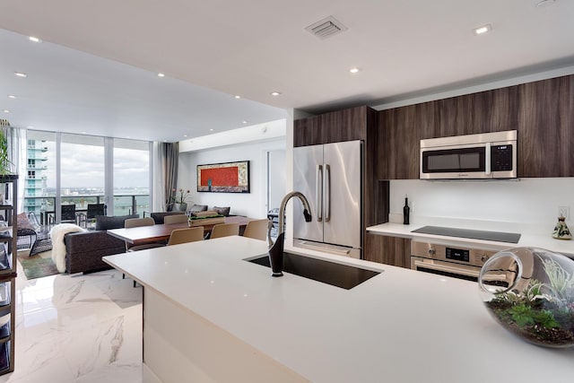 488 NE 18th St Unit 4711, Miami, FL 33132 - kitchen featuring appliances with stainless steel finishes, modern cabinets, light marble finish flooring, light countertops, and dark brown cabinets