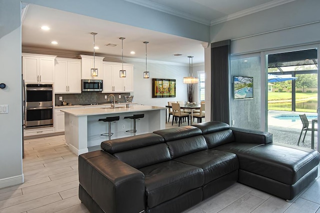 3165 Berkley Square Way, Vero Beach, FL 32966 - living area featuring healthy amount of natural light, light wood-style flooring, recessed lighting, and ornamental molding