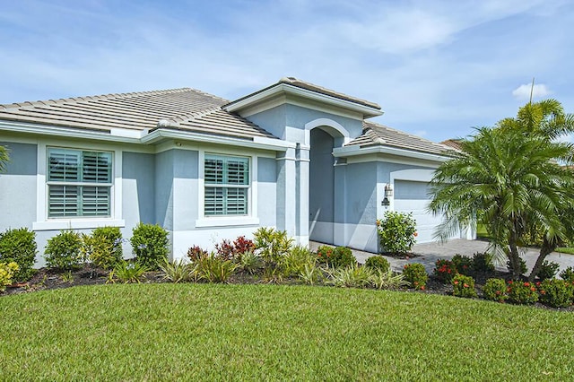 3165 Berkley Square Way, Vero Beach, FL 32966 - ranch-style home featuring a garage, stucco siding, a front yard, and a tile roof