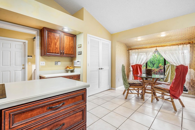 2029 Greenview Cove Dr, Wellington, FL 33414 - kitchen featuring lofted ceiling, light countertops, light tile patterned floors, and brown cabinetry