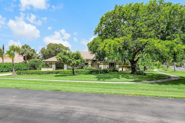 2029 Greenview Cove Dr, Wellington, FL 33414 - obstructed view of property featuring a front lawn, a tiled roof, and stucco siding