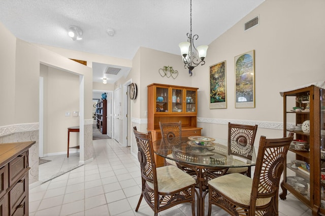 4640 Homestead Way Unit 39, West Palm Beach, FL 33417 - dining space featuring light tile patterned flooring, vaulted ceiling, a chandelier, and a textured ceiling