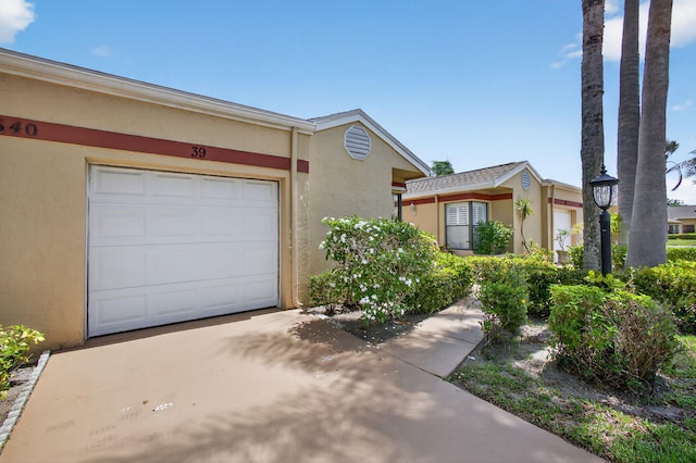 4640 Homestead Way Unit 39, West Palm Beach, FL 33417 - view of property featuring driveway, stucco siding, and an attached garage