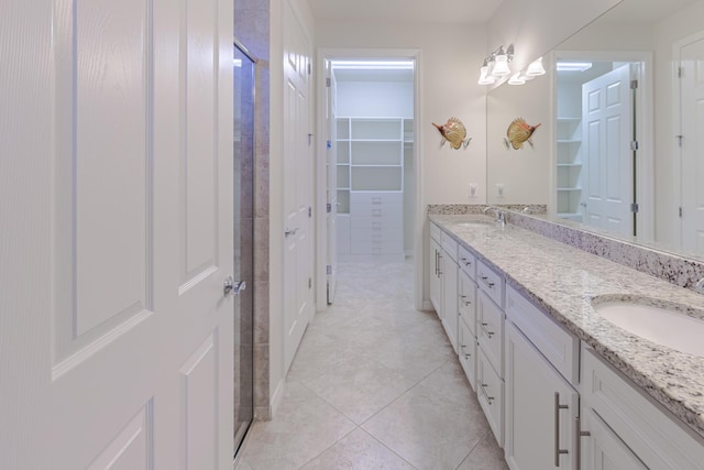 649 SE Monteiro Dr, Port Saint Lucie, FL 34984 - bathroom with double vanity, tile patterned flooring, and a spacious closet