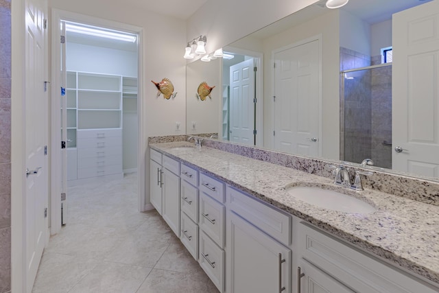 649 SE Monteiro Dr, Port Saint Lucie, FL 34984 - bathroom with double vanity, a shower stall, a spacious closet, and tile patterned flooring