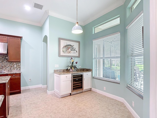 780 SW Fortunella Cir SW, Vero Beach, FL 32968 - indoor bar with beverage cooler, arched walkways, decorative backsplash, ornamental molding, and decorative light fixtures