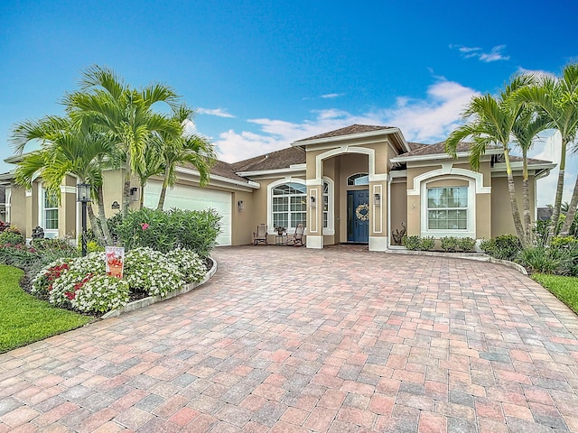 780 SW Fortunella Cir SW, Vero Beach, FL 32968 - mediterranean / spanish-style house featuring stucco siding, an attached garage, and decorative driveway