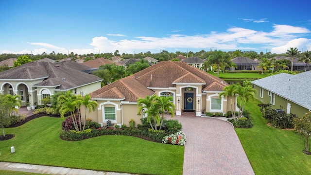 780 SW Fortunella Cir SW, Vero Beach, FL 32968 - mediterranean / spanish home with decorative driveway, stucco siding, a front yard, and a residential view
