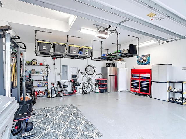 780 SW Fortunella Cir SW, Vero Beach, FL 32968 - garage featuring freestanding refrigerator, electric panel, and a garage door opener