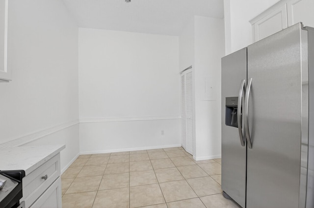 5235 Europa Dr Unit K, Boynton Beach, FL 33437 - kitchen featuring stainless steel refrigerator with ice dispenser, white cabinetry, light tile patterned flooring, and light stone countertops