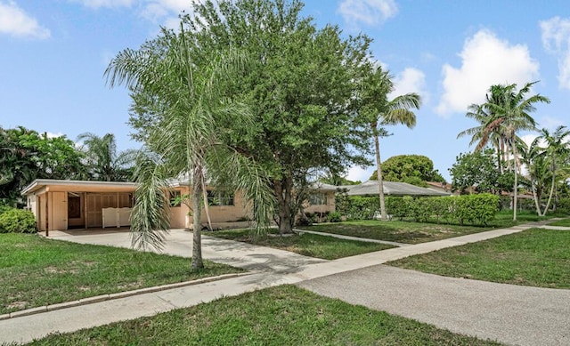 4840 Pineaire Ln, West Palm Beach, FL 33417 - view of front of property featuring concrete driveway, an attached carport, and a front lawn